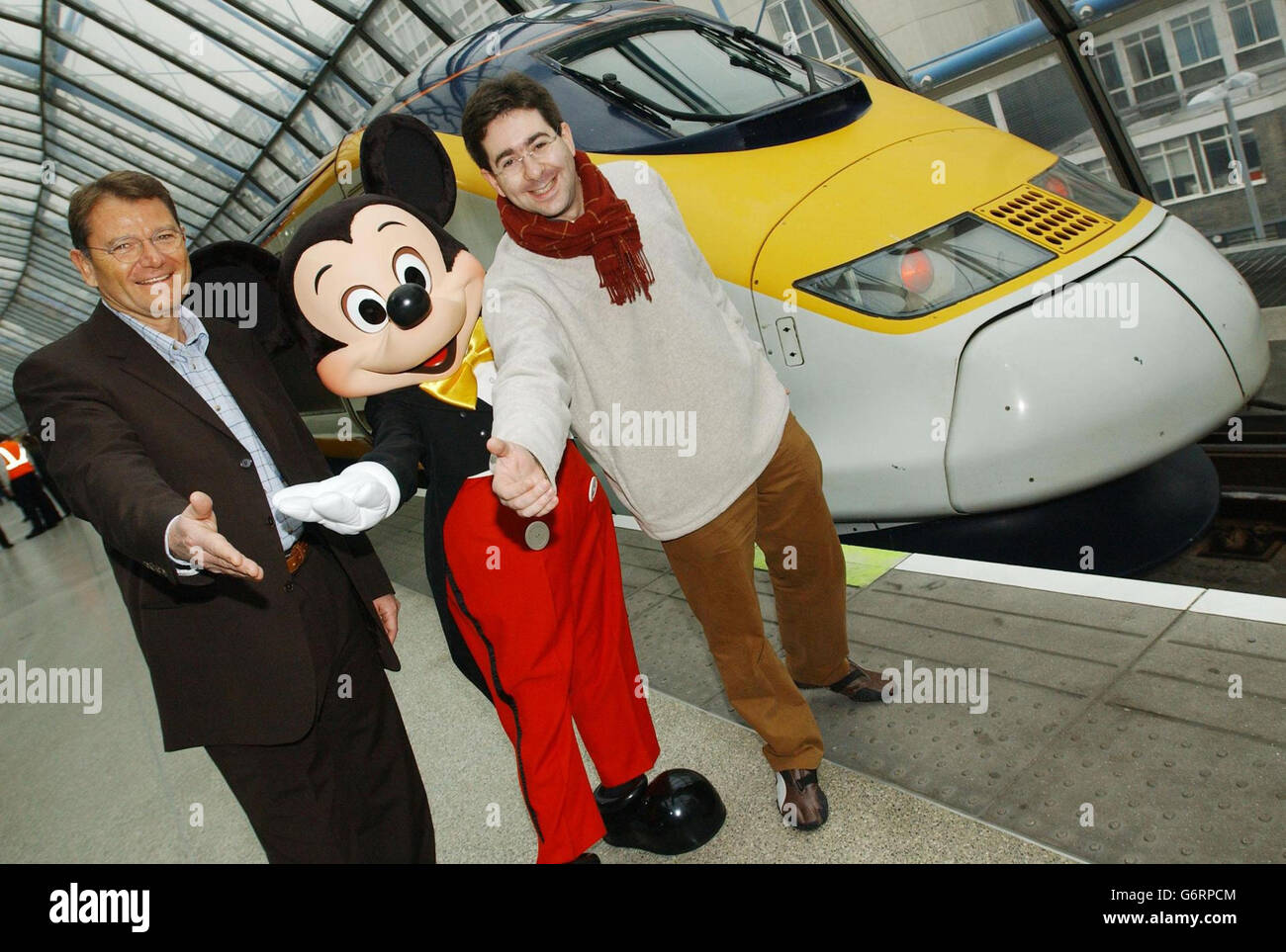 Mickey Mouse' with Yann Caillere ( left), President and COO of Disneyland Resort Paris and Paul Charles, Eurostar's Director of Communications, at the nosecone of a Eurostar train liveried with Disney characters, before departing from Waterloo to the resort. Stock Photo