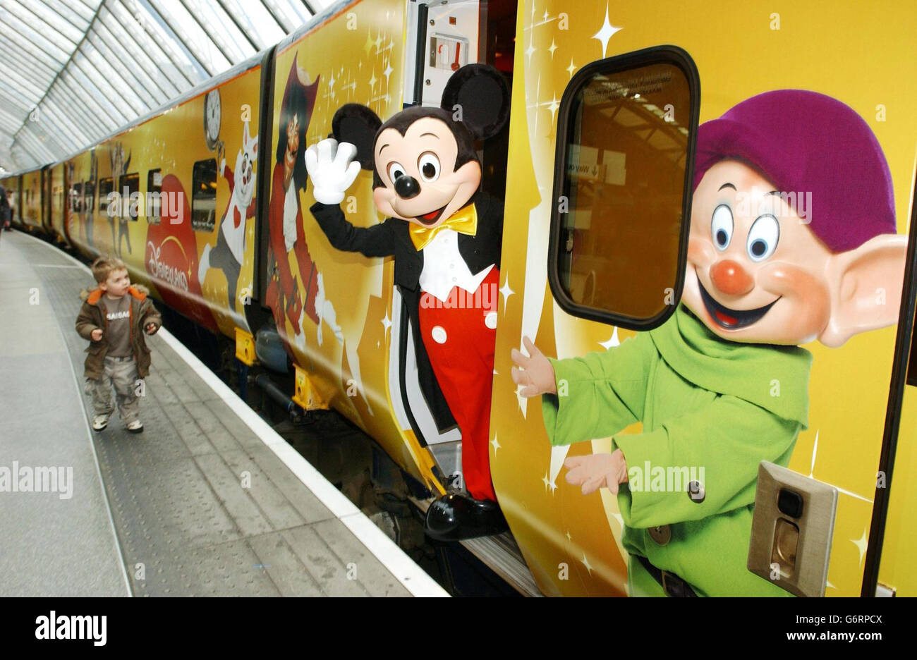 Mickey Mouse' with Yann Caillere ( left), President and COO of Disneyland Resort Paris and Paul Charles, Eurostar's Director of Communications, at the nosecone of a Eurostar train liveried with Disney characters, before departing from Waterloo to the resort. Stock Photo