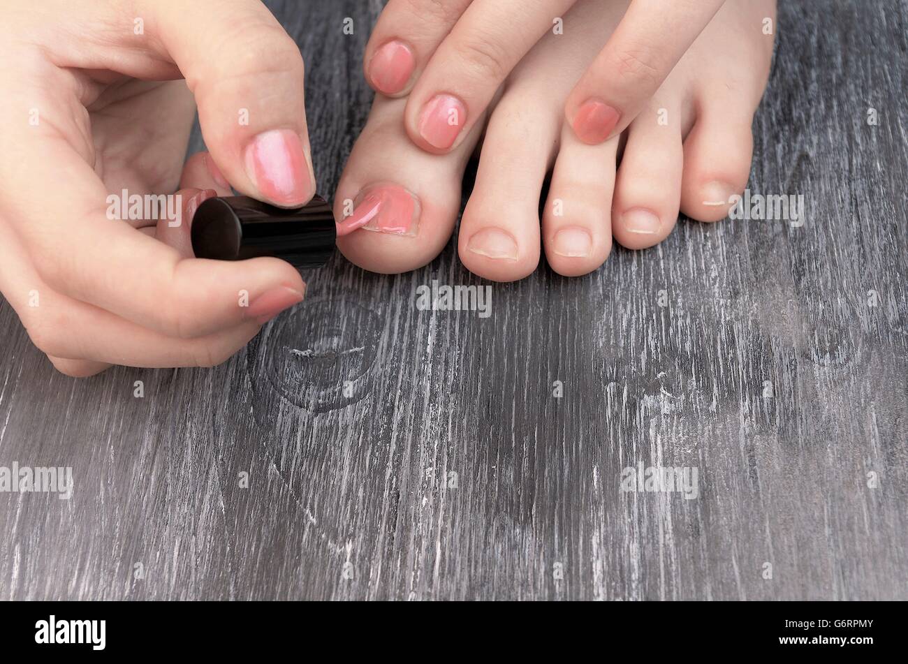 teen applying nail polish to hands and feet fingers Stock Photo - Alamy