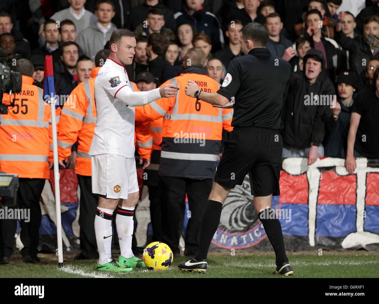 Soccer - Barclays Premier League - Crystal Palace v Manchester United - Selhurst Park. Manchester United's Wayne Rooney (left) hands over an object thrown from the crowd to referee Michael Oliver Stock Photo