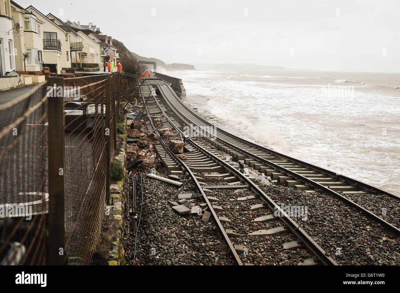 A huge length of railway track is exposed and left hanging after the sea wall collapsed in Dawlish, where high tides and strong winds have created havoc in the Devonshire town disrupting road and rail networks and damaging property. Stock Photo