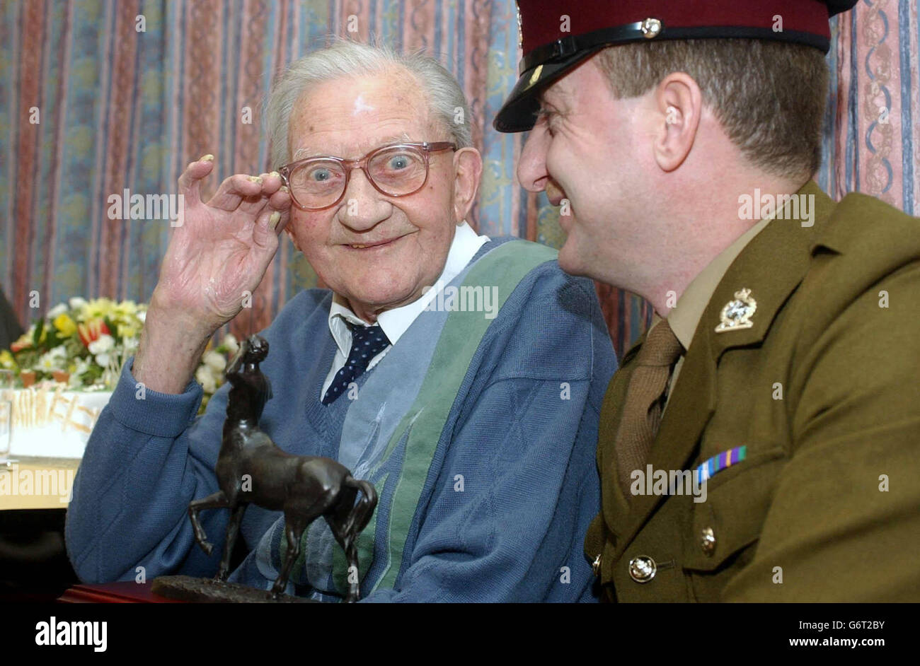 Former member of the Royal Army Veterinary Corps Frederick Charles Lloyd, salutes his modern day counterpart, Sergeant Major Paul Williams, as he is presented with a bronze centaur (the Corps emblem) during a party to celebrate his 106th birthday at Uckfield Civic Centre, East Sussex. One of the last surviving combatants of the First World War - thought now to number 26 - Fred saw service on the Western Front. Stock Photo