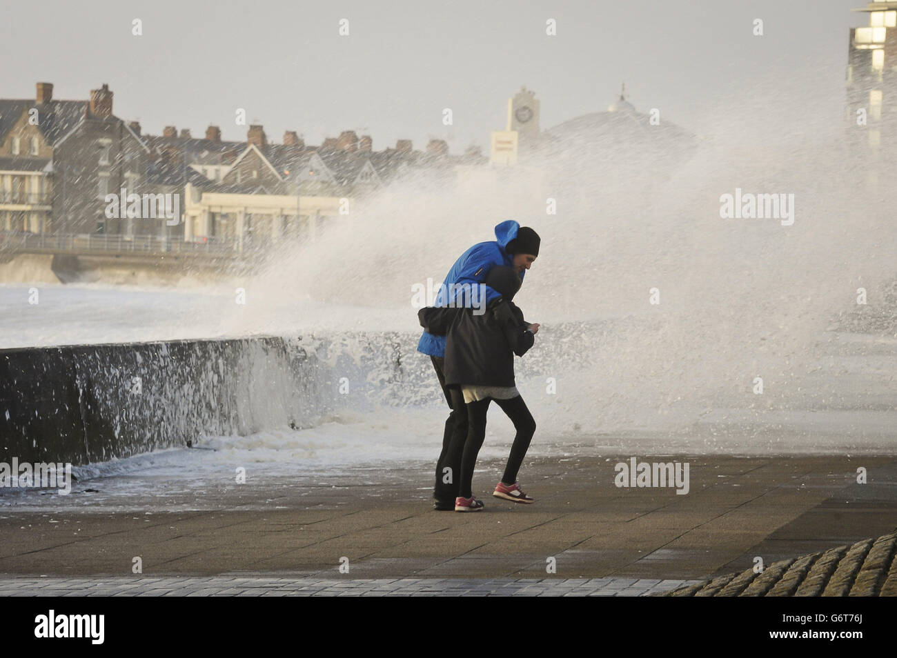 People struggle to make their way along the Esplanade, Porthcawl, south Wales, as the region continues to be battered high winds and heavy rain. Stock Photo