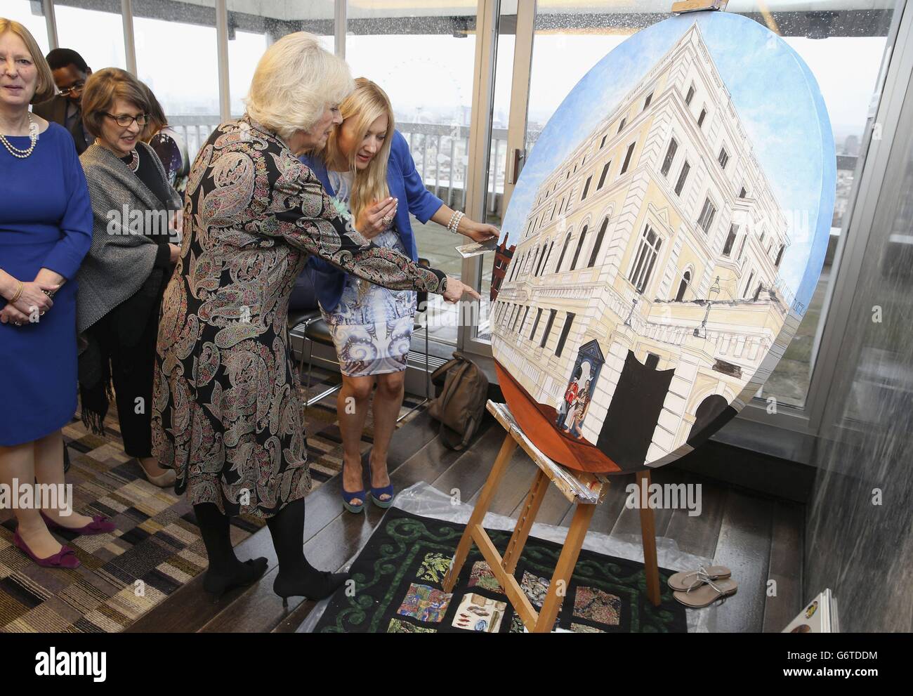 The Duchess of Cornwall helps put the finishing touches to NZL artist Mandii Pope's Maori-themed painting of Clarence House during a celebration of the success of New Zealand women in the UK on Waitangi day held at New Zealand House, central London. Stock Photo