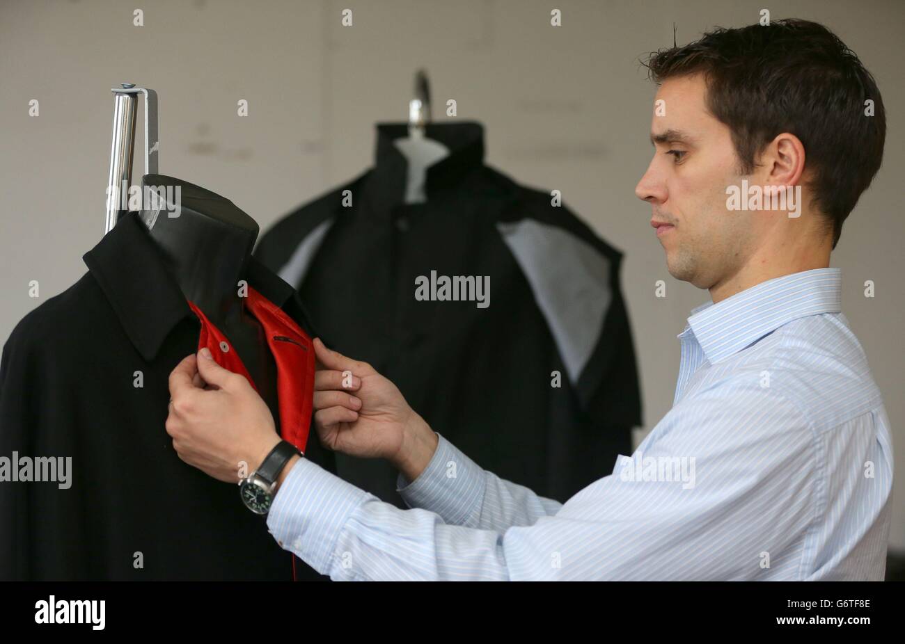 Auctioneer Paul Fairweather with jackets worn by George Harrison (right ...