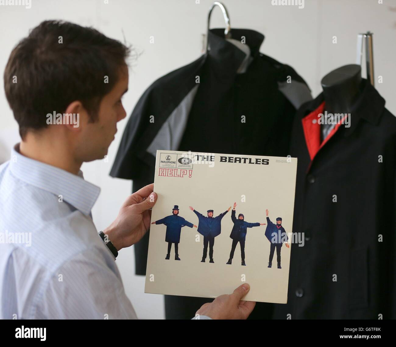 Auctioneer Paul Fairweather with jackets worn by George Harrison (right ...