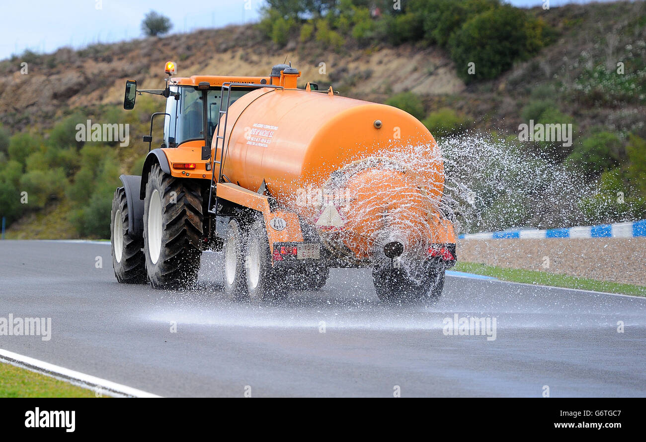 A tractor sprays water to wet the track to make the morning session an ...