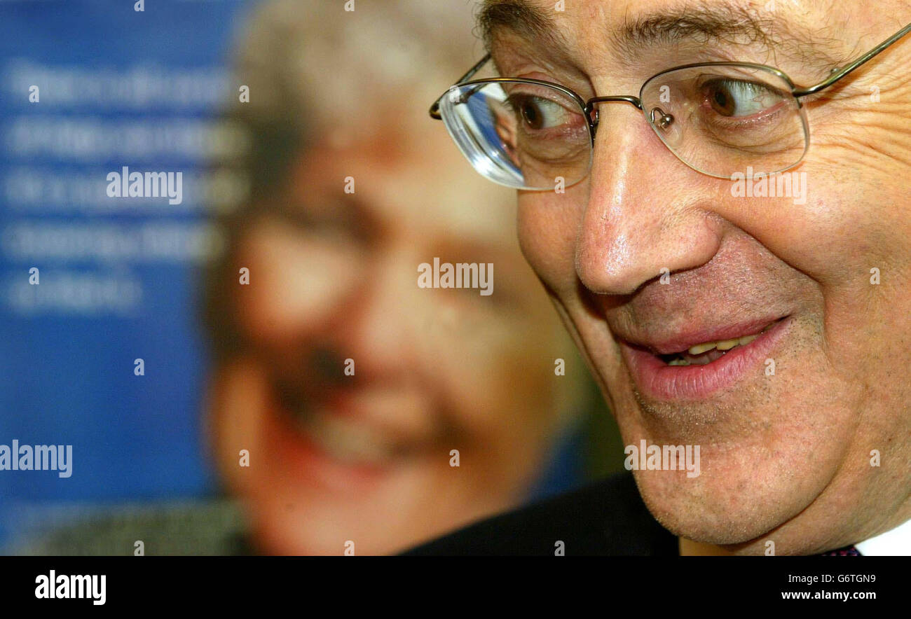 Michael Howard, leader of the Conservative party, in Scotland at Castle Douglas's main post office in front of a poster of an old age penioner. He was talking about pension books and the government's new direct payment scheme. Stock Photo