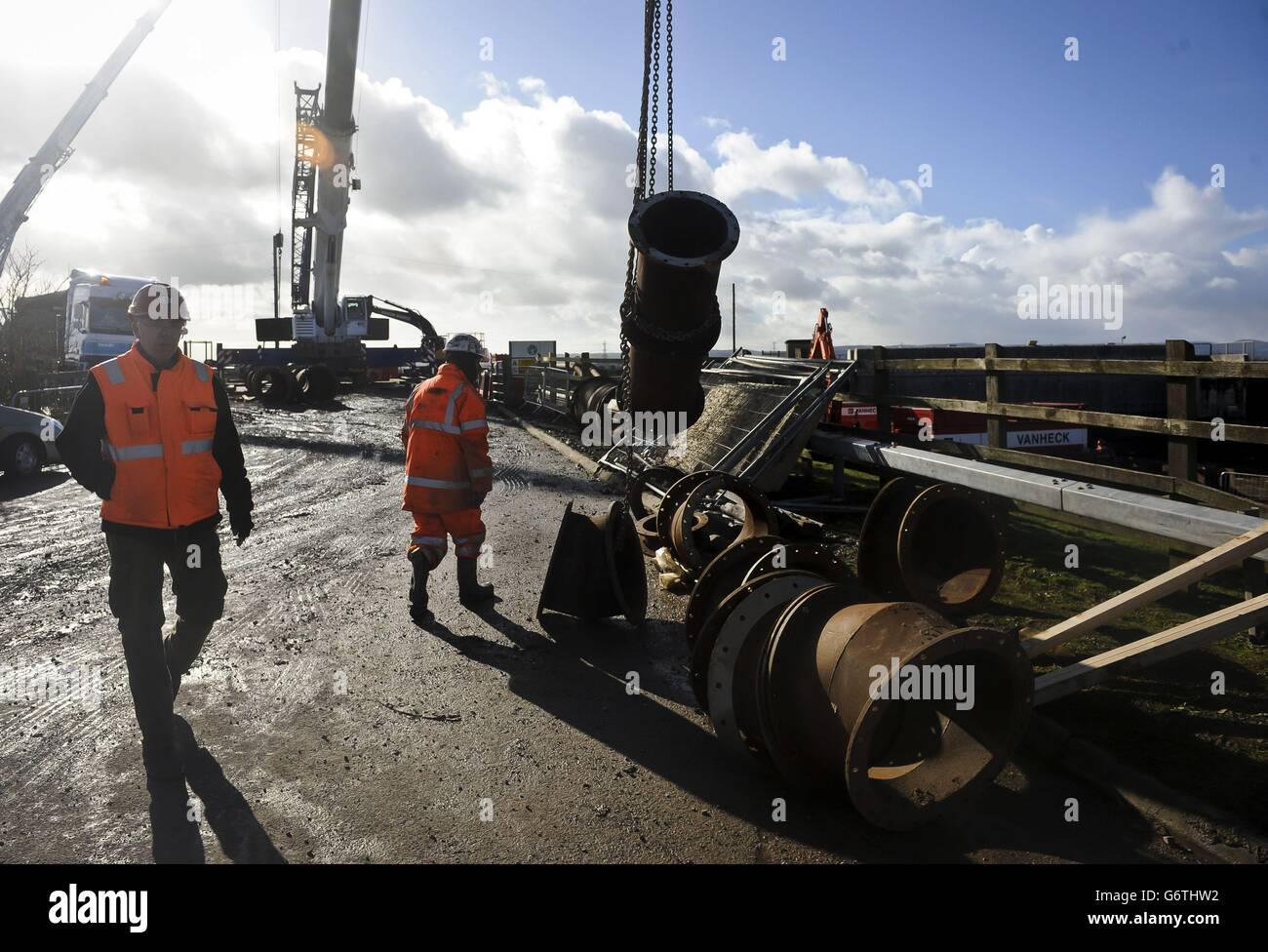 Workers move massive water pipes as a huge imported Dutch pumping station is set up at Dunball, near Bridgwater, Somerset, at the base of King's Sedgemoor Drain, which is an artificial drainage channel running off the Somerset Levels. Stock Photo