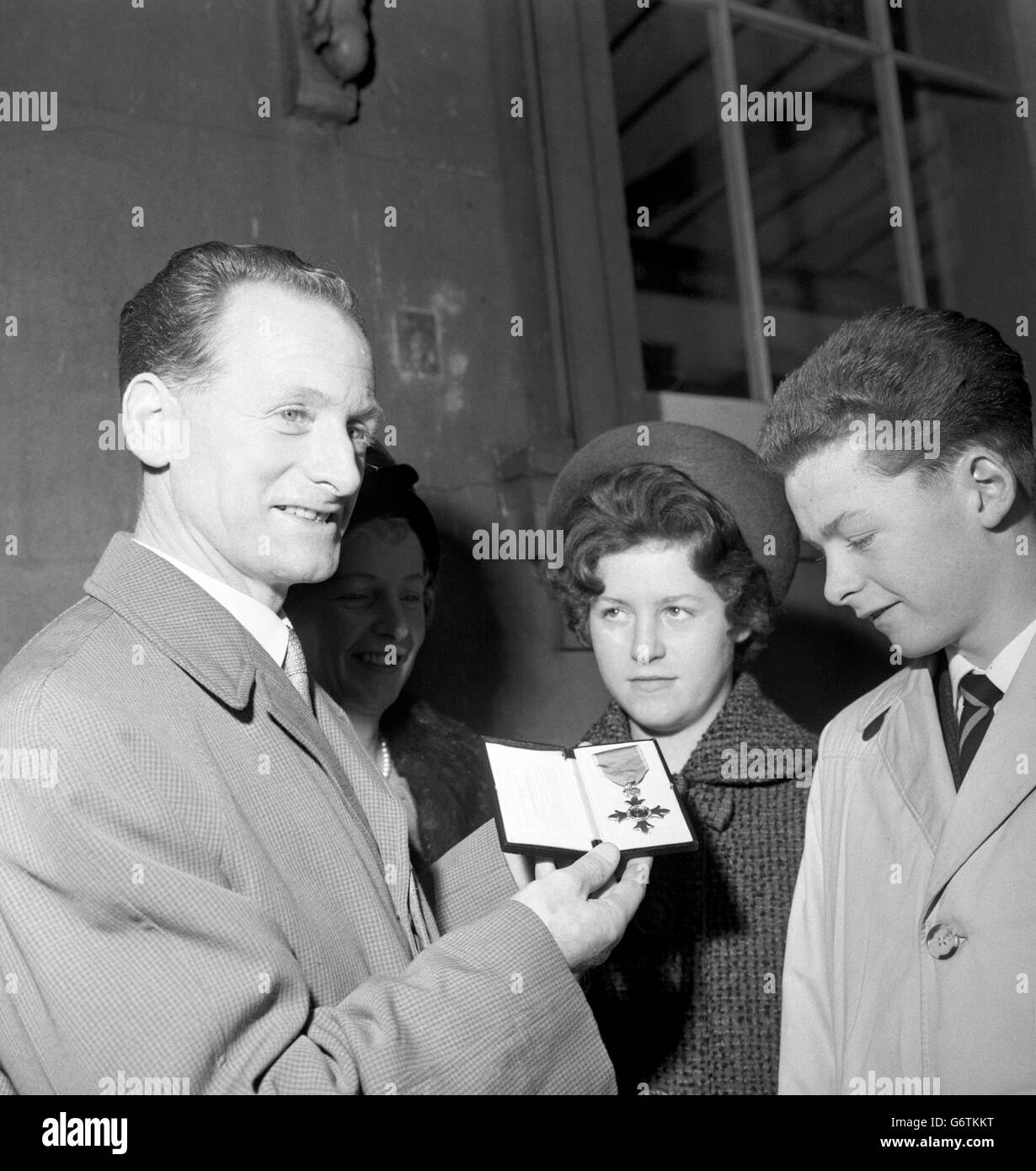 Former England and Preston North End footballer Tom Finney outside Buckingham Palace with his OBE. With him are his wife Elsie, daughter Barbara, 11, and son Brian, 13. Stock Photo