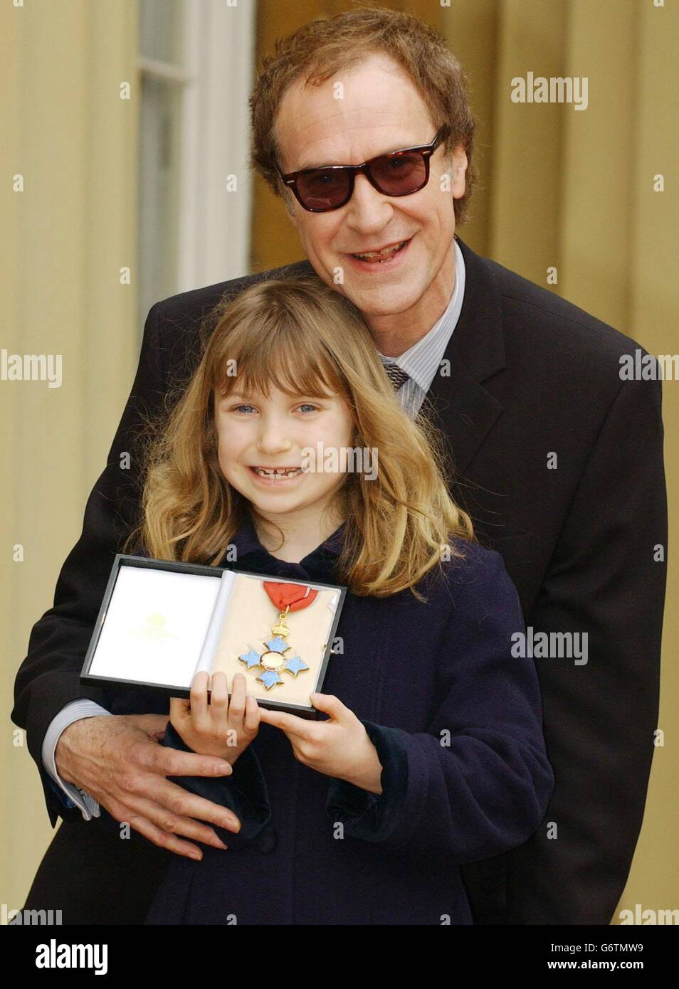Legendary Sixties singer Ray Davies, 59, from the band The Kinks stands with his daughter, Eva, age 7, after he received a CBE for services to music in the New Year Honours List, during an Investiture ceremony held at Buckingham Palace, London. Davies, classic hits include Waterloo Sunset, You Really Got Me, All Day And All Of The Night, Dedicated Follower of Fashion, Sunny Afternoon and Lola. Stock Photo