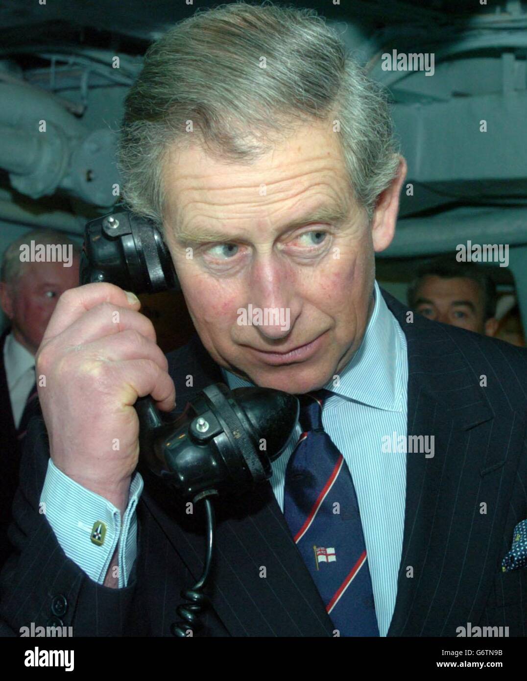 The Prince of Wales aboard HMS Belfast, using the ships telephone during his visit to the The White Ensign Association. The charity's headquarters are located onboard HMS Belfast which is moored on the south bank of the River Thames in London. The Association was founded by the Royal Navy and the City of London in 1958. Stock Photo