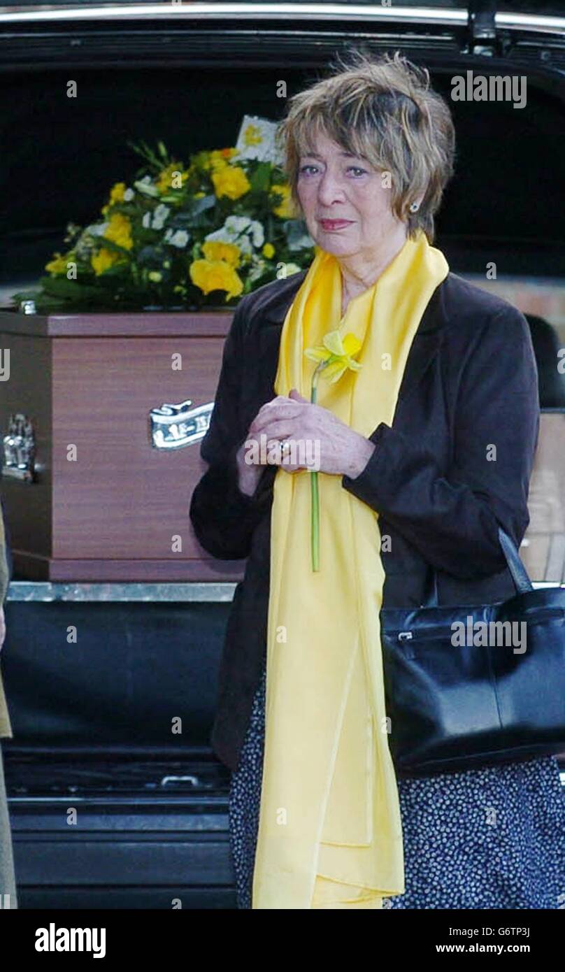 The partner of Robin Hunter, Aline Waites, holds a daffodil as she stands besides Mr Hunter's coffin as it arrives in a hearse at Golders Green Crematorium in north London. Mr Hunter 74, died from emphysema at his Hampstead home earlier this month. The son of Hollywood actor Ian Hunter, Robin Hunter starred in a string of West End musical hits and appeared on film and television. Stock Photo