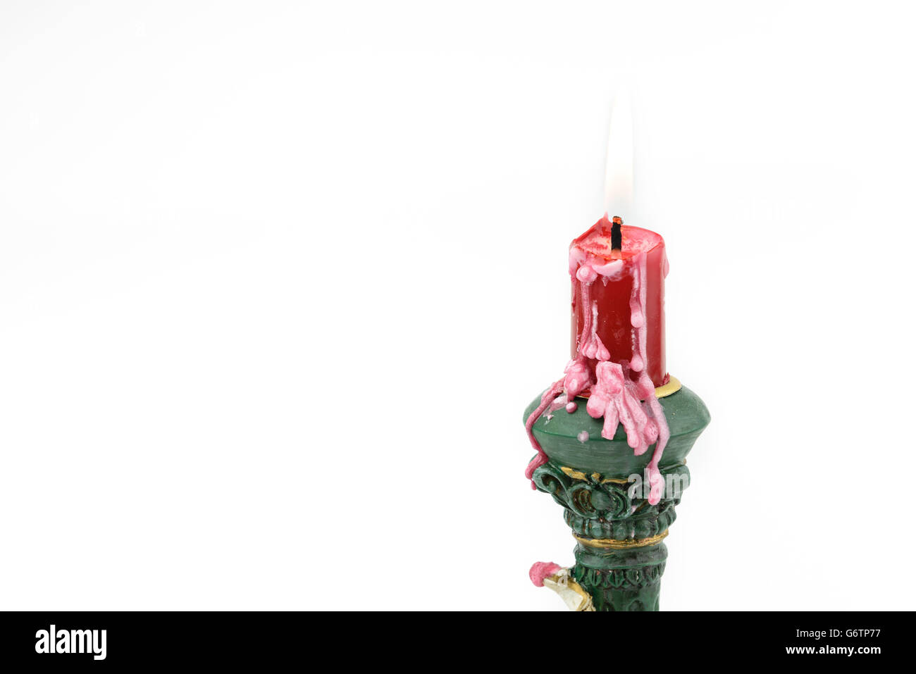 Bruning red aroma candle, with wax on cupid holder, isolated white background Stock Photo