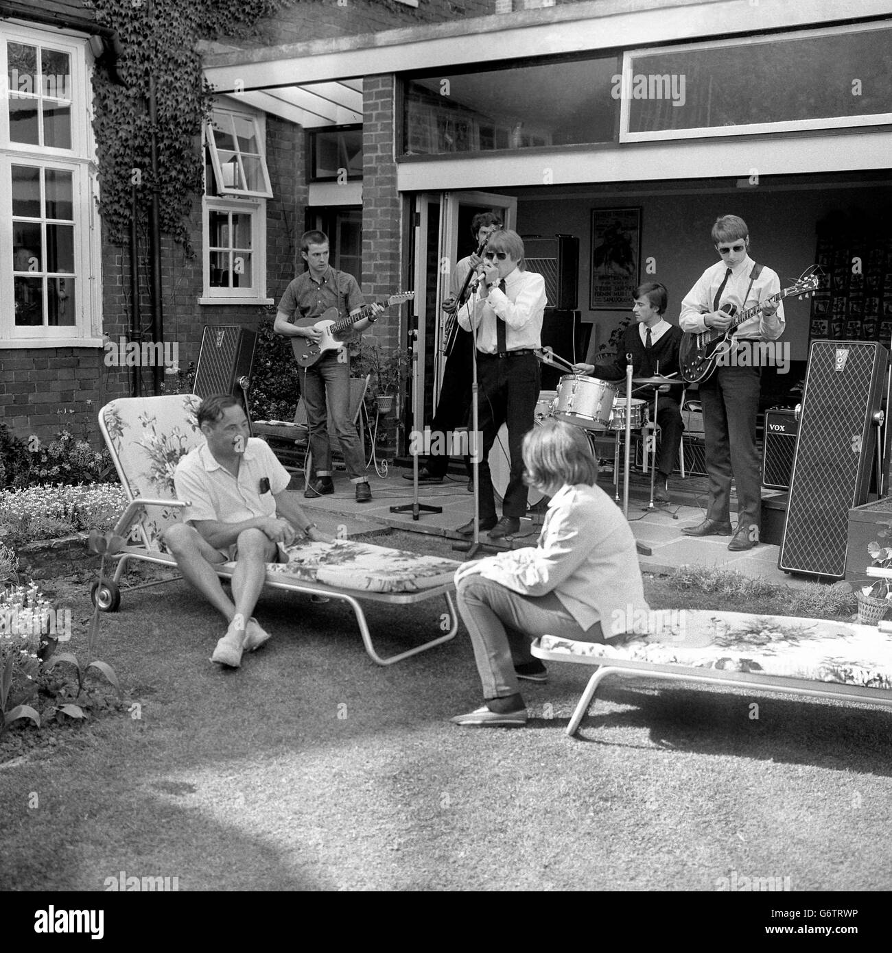 Lord Willis, who recently attacked &#8216;The Beatle Cult&#8217; in a House of Lords speech is pictured with his daughter Sally, as they listen to the Yardbirds in the back garden of his home in Shepherd&#8217;s Green, Chislehurst, Kent. The Yardbirds, a pop-group of five ex-public school boys from the Richmond area of Surrey, had unexpectedly visited Lord Willis to explain &#8216;what pop music is all about&#8217;. Lord Willis, the scriptwriter who created television&#8217;s &#8216;Dixon of Dock Green&#8217; invited them into the garden where he was sunning himself. After a discussion, he Stock Photo