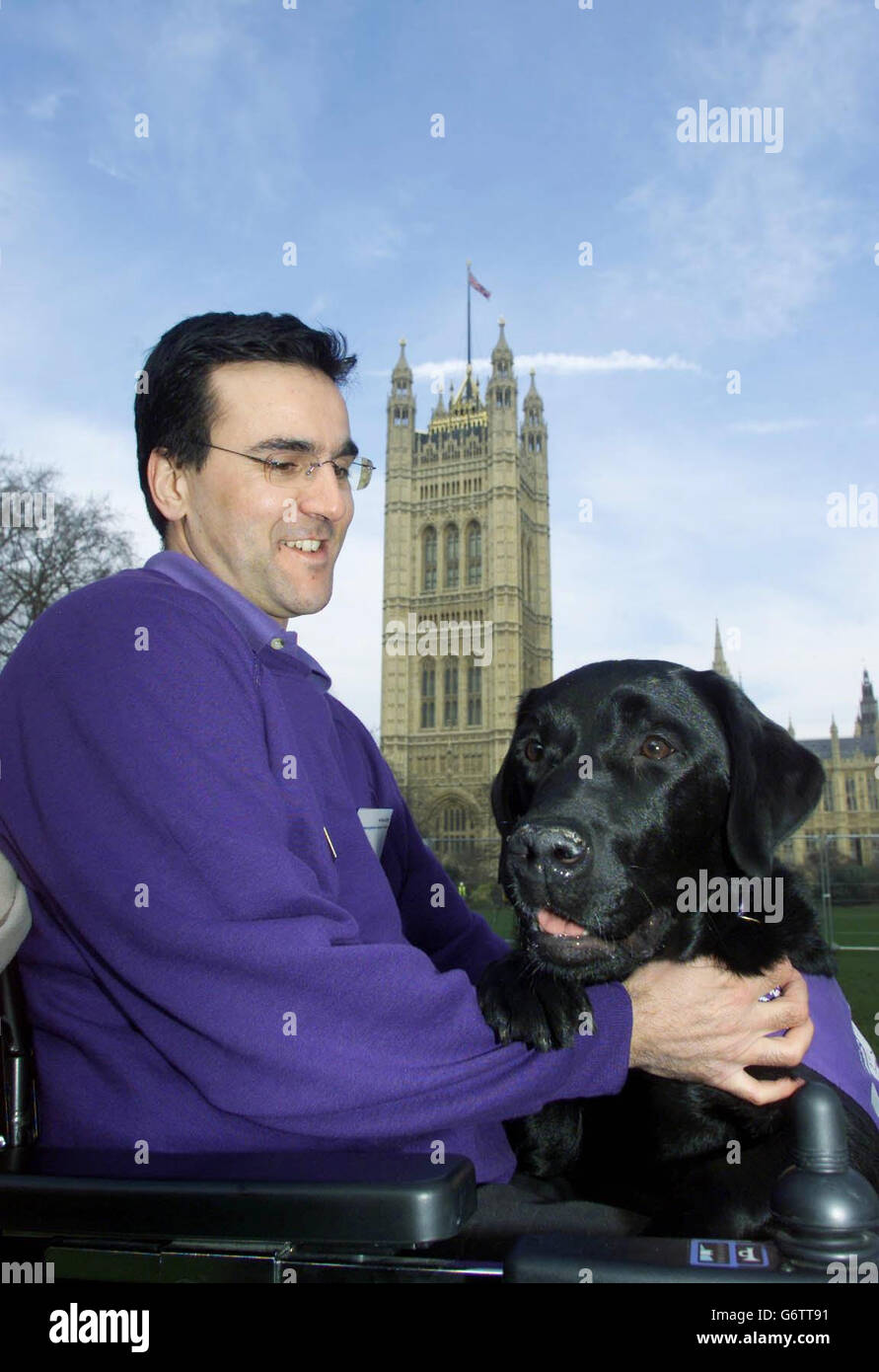 Pet owner, Spiro Sueref and Jake the Dog from Fourmark in Hampshire both members of Canine Partners, stand in Victoria Tower Gardens , Westminster before going into Parliment. Jake, will join assorted dogs and a pony on a visit to the House of Lords when representatives of animal charities and associated organisations hosted by the National Office for Animal Health (Noah) demonstrate the beneficial effect that animals have on human lives. Stock Photo