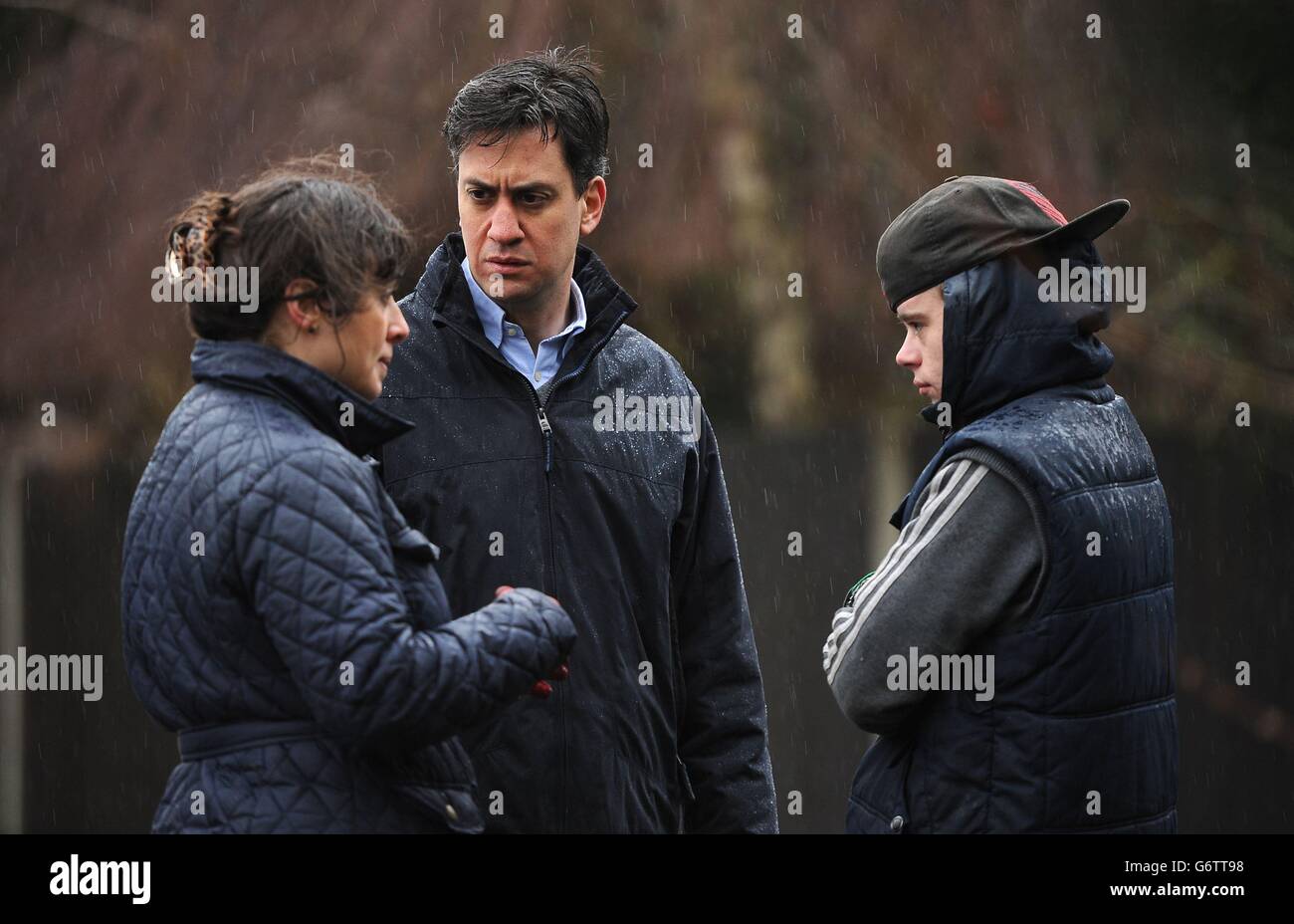 Labour leader Ed Miliband (right) and Labour's Parliamentary Candidate for Reading West, Victoria Groulef (left), speak with a local resident during a visit to the view recent flooding in Purley on Thames in Berkshire. Stock Photo