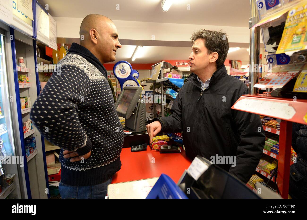 Labour leader Ed Miliband (right) speaks with a local shop owner during a visit to view recent flooding in Purley on Thames in Berkshire. Stock Photo