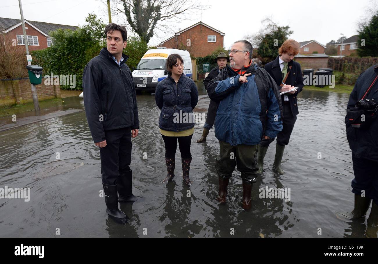Labour leader Ed Miliband (left) and Labour's Parliamentary Candidate for Reading West, Victoria Groulef (centre), speak with a local resident during a visit to view recent flooding in Purley on Thames in Berkshire. Stock Photo