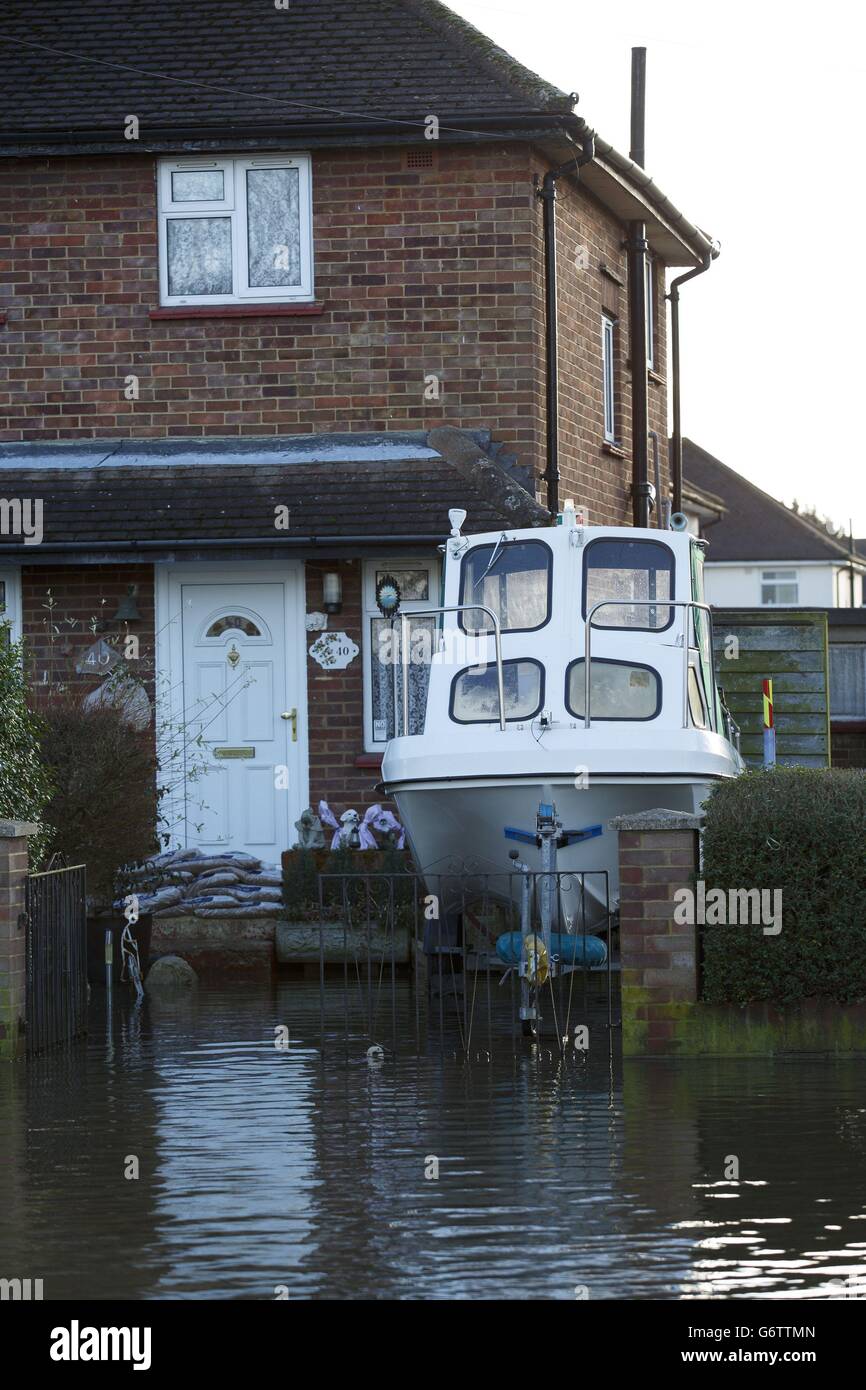 A boat is parked in the flooded driveway of a house in Egham, Surrey. Stock Photo
