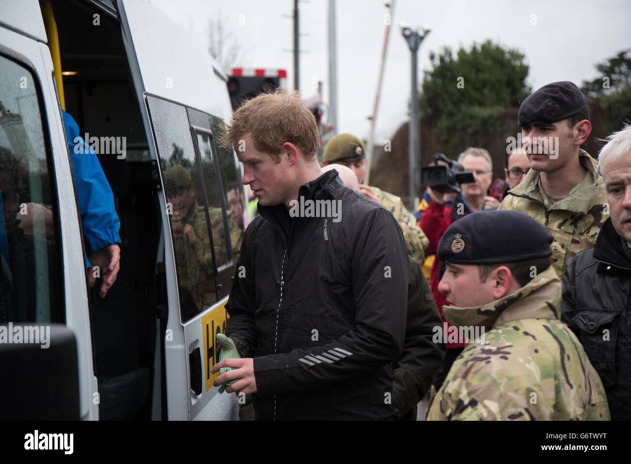 Prince Harry and the Duke of Cambridge (inside coach) in Datchet, Berkshire, as they joined colleagues from the armed forces in helping to defend the town from the floods that have brought misery to much of southern England. Stock Photo