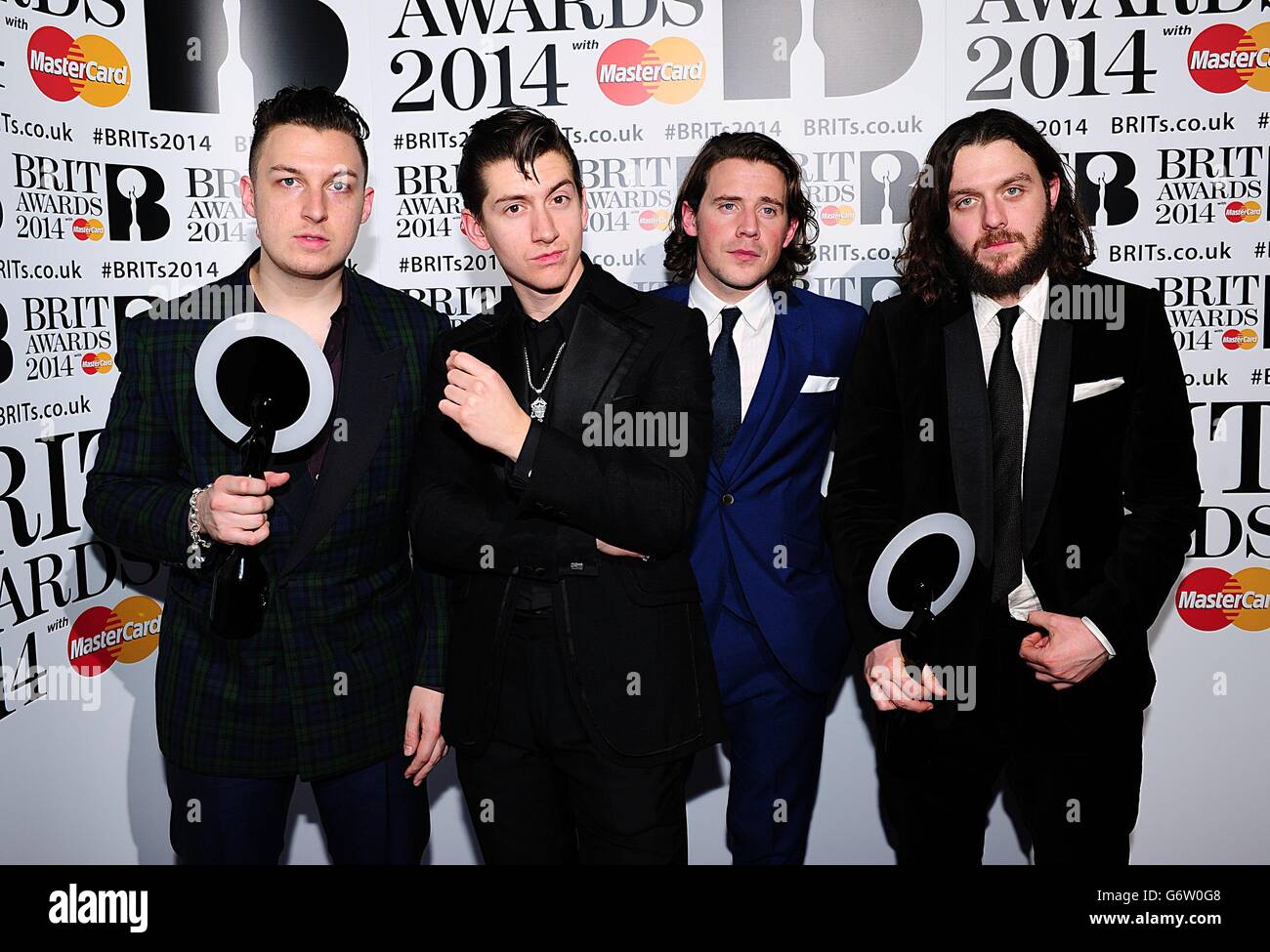 (L-R) Matt Helders, Alex Turner Jamie Cook and Nick O'Malley from Arctic Monkeys with their awards in the press room at the 2014 Brit Awards at the O2 Arena, London. Stock Photo