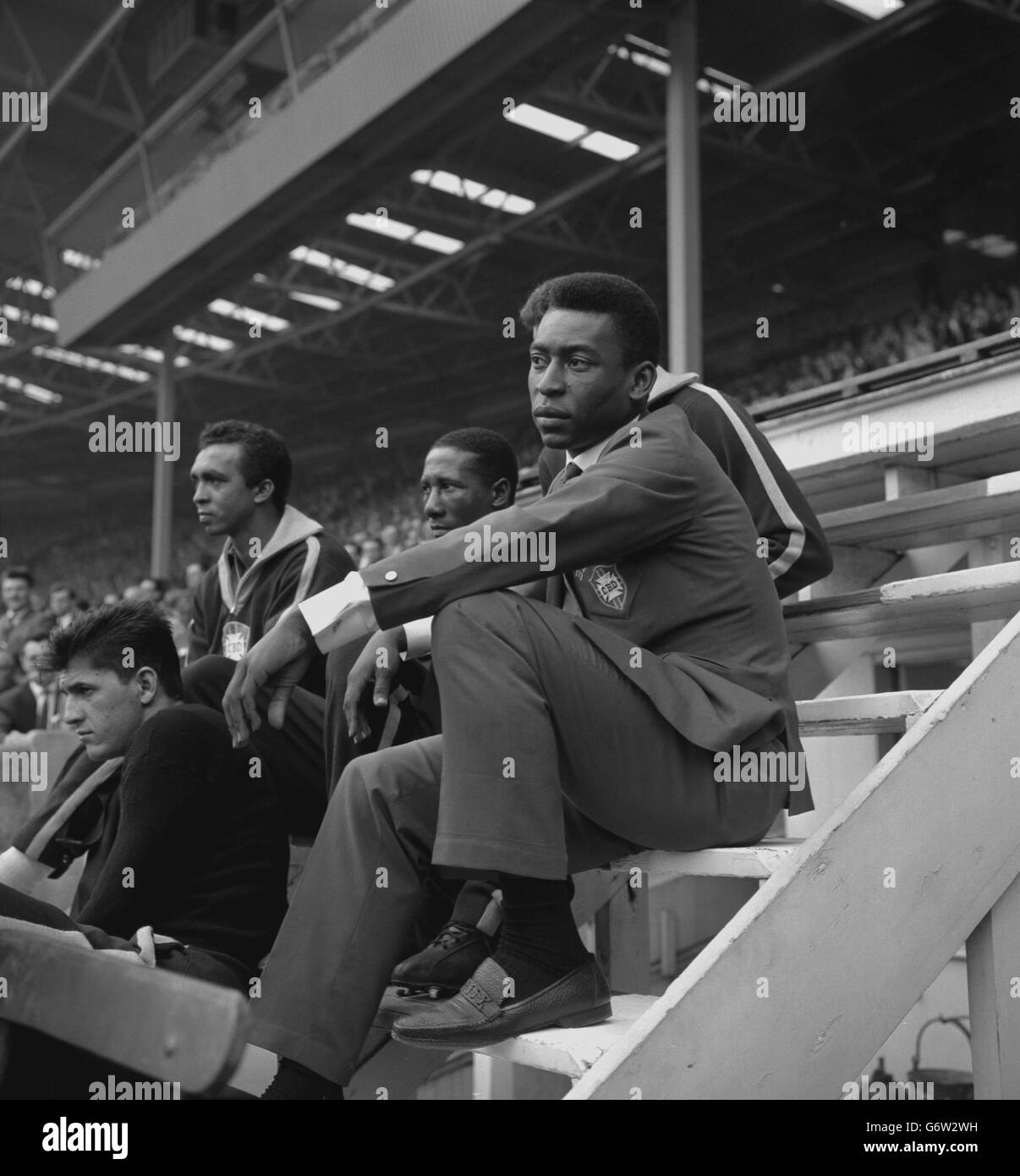 Brazilian footballer Pele (r), still feeling the effects of injuries sustained in a crash in Hamburg, sits in the stand during the international friendly against England at Wembley Stadium, London. Just before kick-off, a near-capacity crowd booed the announcement that Pele would not be playing. The match ended 1-1. Stock Photo