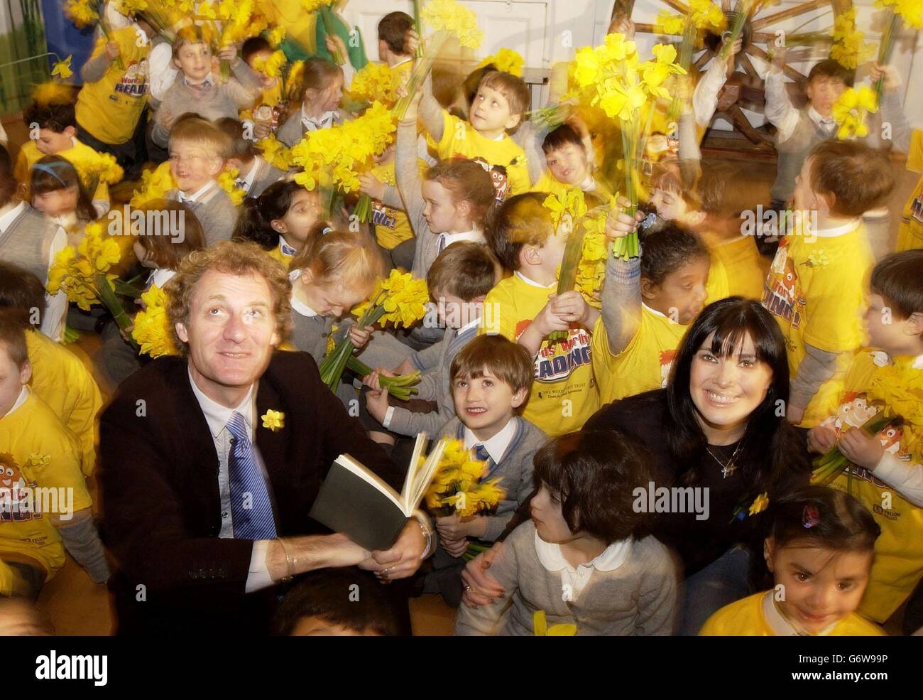 Poet Laureate Andrew Motion and singer Kym Ryder with pupils from Hampstead Hill School, north London, during Words Worth Reading, a recital of Wordsworth's 'Daffodils' poem and attempt to break the record for the world's largest ever involving more than 250,000 pupils from 1,100 schools across the UK. The event, organised by Marie Curie Cancer Trust and The Wordsworth Trust, and supported by Yellow Pages, celebrates the bicentenary of Wordsworth's poem. hl190304 Stock Photo