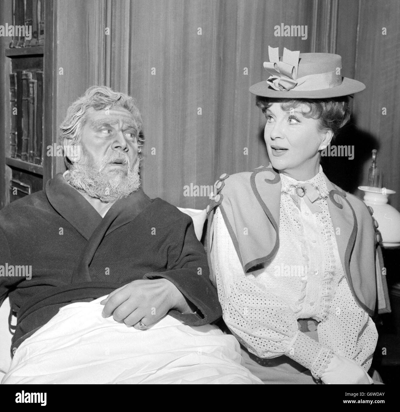 Peter Ustinov, who plays the part of Sam, an 80-year-old best-selling novelist, gets a bedside visit from Diana Wynyard, as his wife stella, during rehearsal at the Saville Theatre, London, of Mr Ustinov's new play 'Photo Finish' which begins its West End run at the Saville after touring Dublin, Newcastle and Leeds. Stock Photo