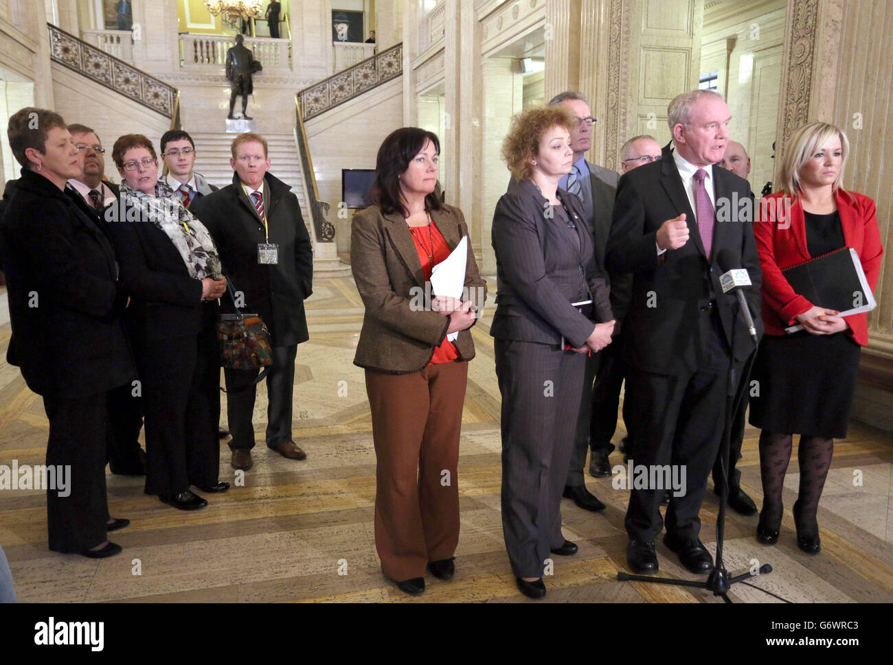 Victims' families listen to Martin McGuinness and his Sinn Fein party colleagues speaking to the media, after the Northern Ireland Assembly was recalled to debate the recent letter crisis. Stock Photo