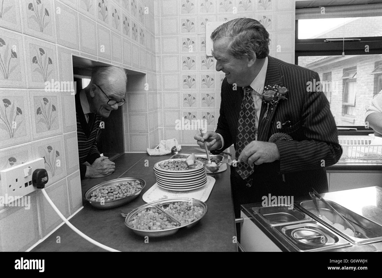 Shadow Foreign Secretary Denis Healey serving lunch for 78-year-old Arthur Brookes at Kingsbridge Old Peoples Home at Wheelers Cross, Barking, east London. Stock Photo