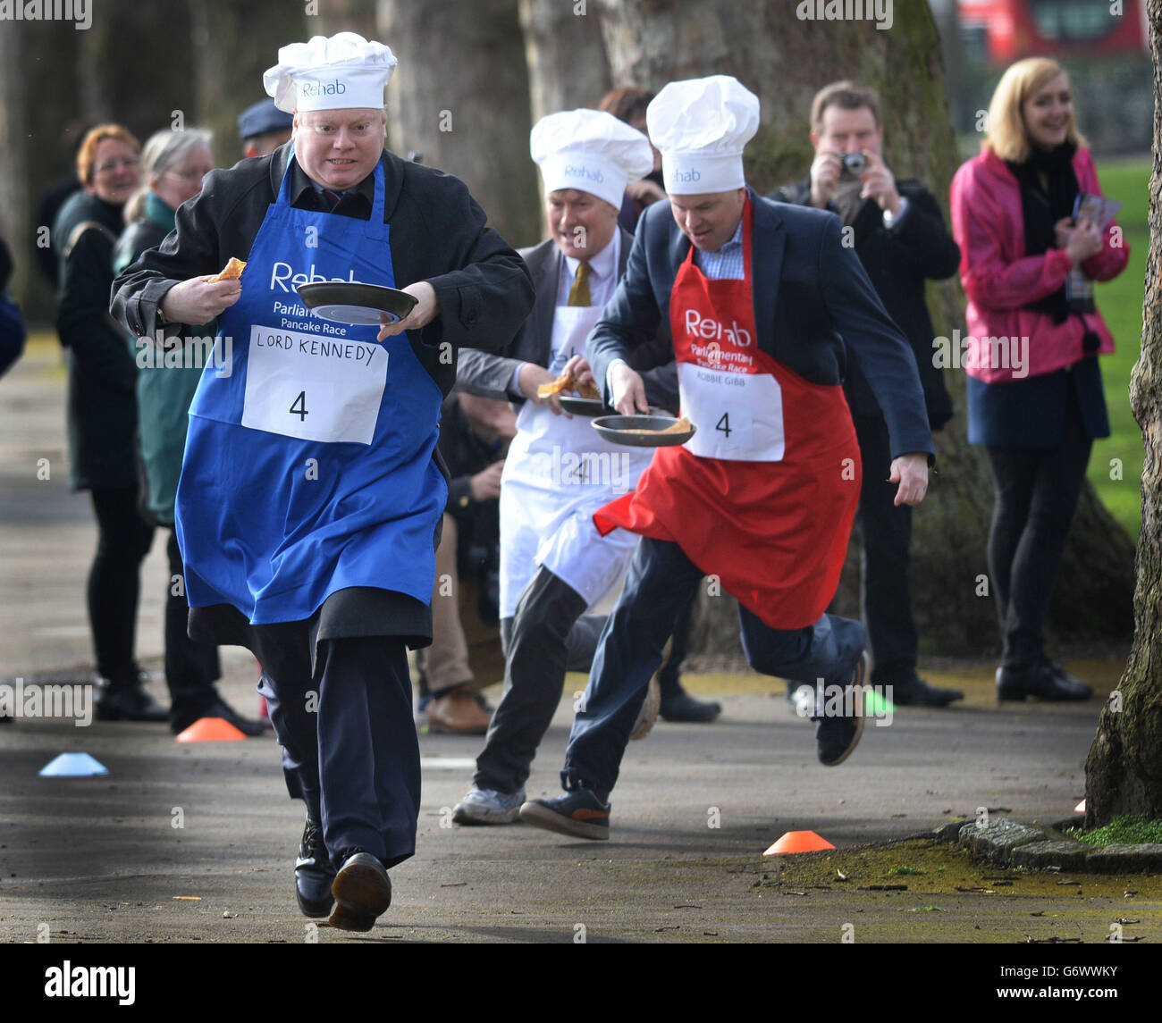 MP David Amess (centre), Lord Kennedy (left) and editor of the Daily Politics, Robbie Gibb (right) take part in the annual Rehab Parliamentary Pancake Race in which MPs, Lords and members of the media race each other on pancake day to raise money for the charity Rehab. Stock Photo