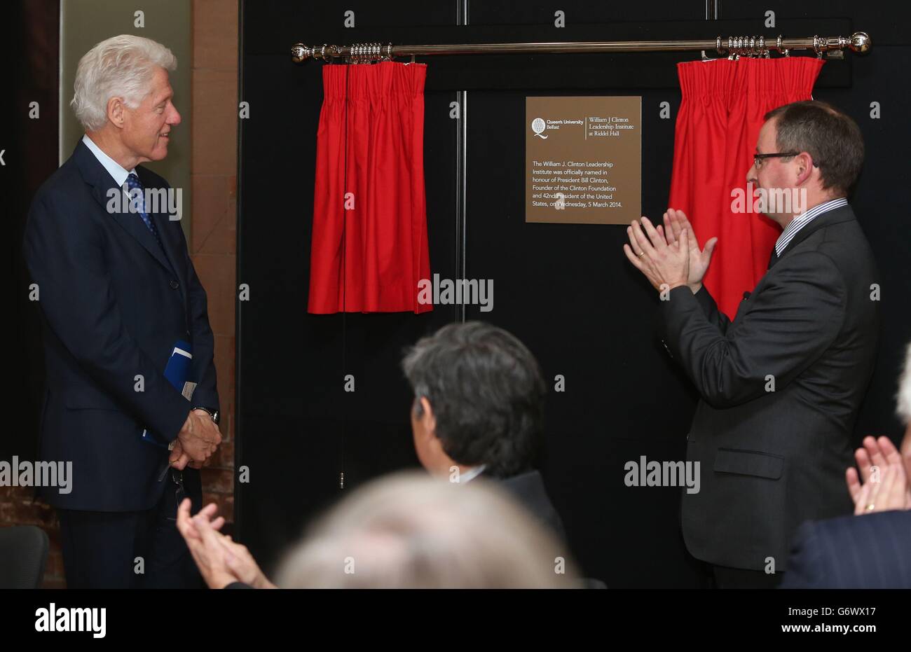 President and Vice-Chancellor of Queen's University Belfast Professor Patrick Johnston (right) applauds former US president Bill Clinton as he unveils a plaque for the William J. Clinton Leadership Institute at Riddel Hall, Queen's University Belfast, Belfast. Stock Photo