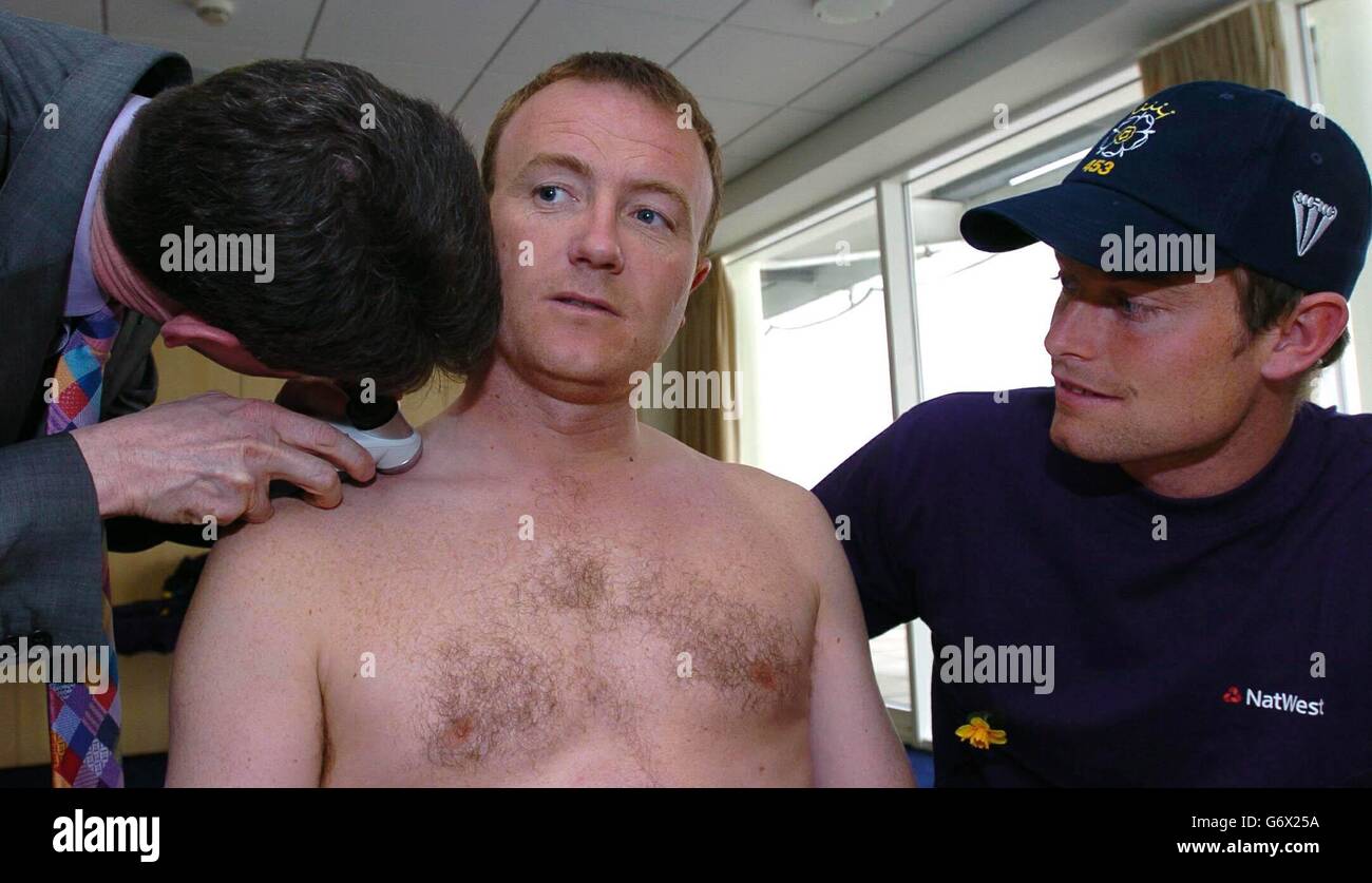 Hampshire cricketer Shaun Udal (midlle) is looked over by Consultant Dermatologist Doctor Steve Keohane (left), who is director of Portsmouth Dermatologist Centre, while being watched by team mate James Hamblin (right), as part of the NatWest/Marie Curie Cancer Care 'Sun Safety - Don't get caught out' campaign, at Hampshire C.C. Rose Bowl Ground Southampton. Stock Photo