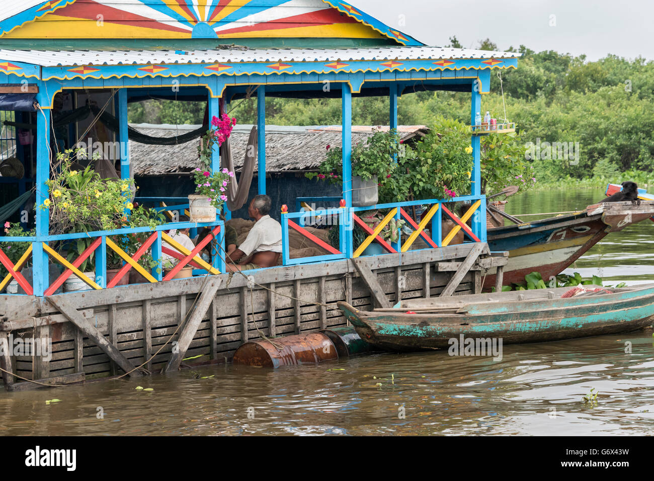 Floating house with flower garden and black dog, Kampong Phluck, Cambodia Stock Photo