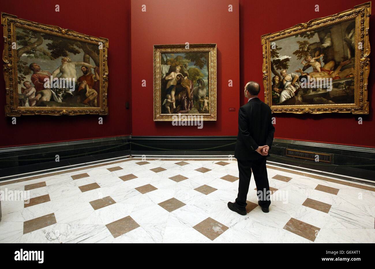 A visitor looks at three works by Paolo Veronese (left to right) Unfaithfullness, Mars and Venus United by Love, and Scorn, during a press preview for the Veronese: Magnificence in Renaissance Venice exhibition at the National Gallery, London. Stock Photo