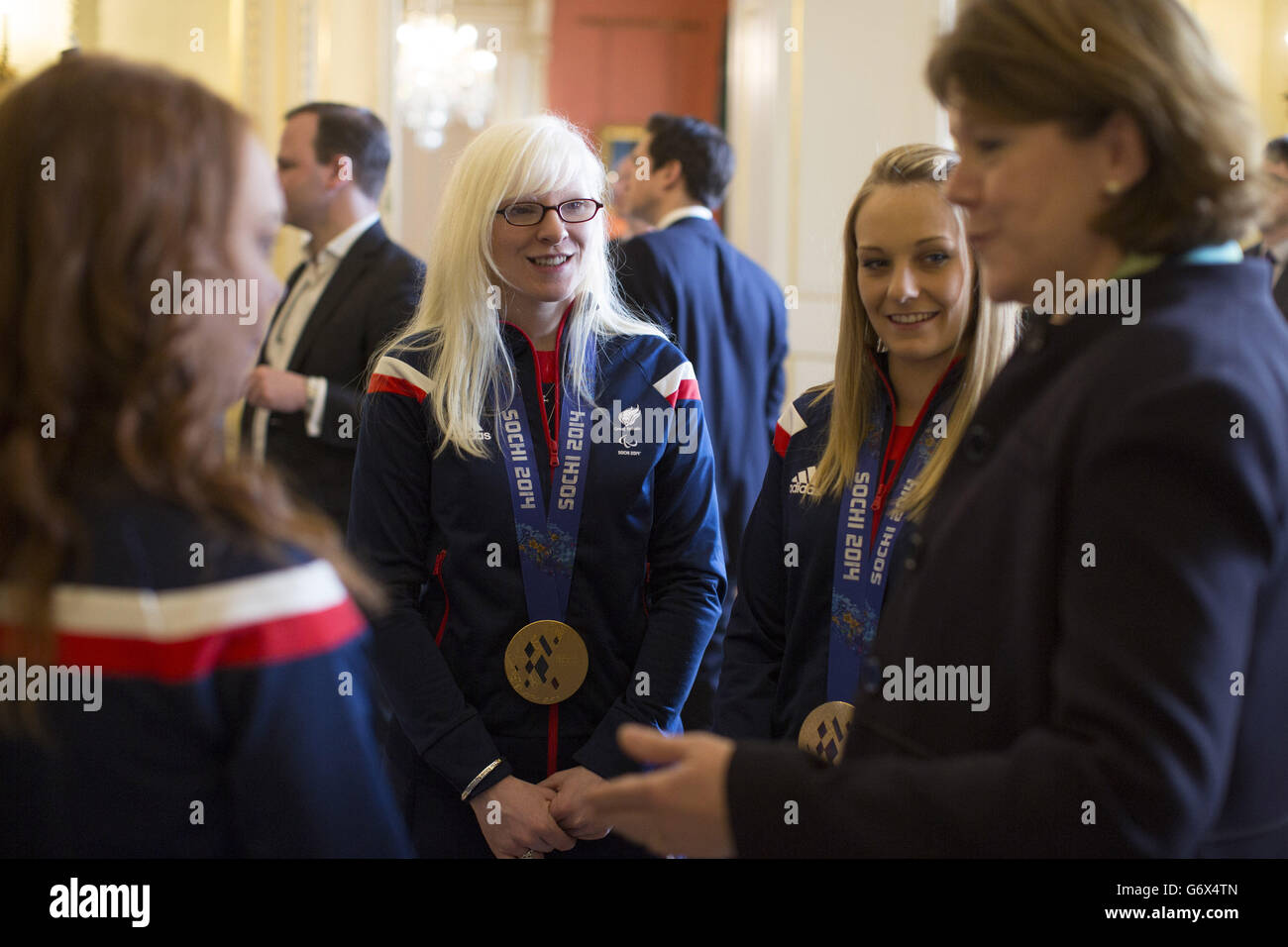 Secretary of State for Culture, Media and Sport Maria Miller (right), greets members of the Winter Paralympic Team GB, including gold medal winning skiers Kelly Gallagher (centre) and Charlotte Evans (second right), during a reception held at Downing Street, central London, following the teams return from the Sochi Paralympic Winter Games. Stock Photo