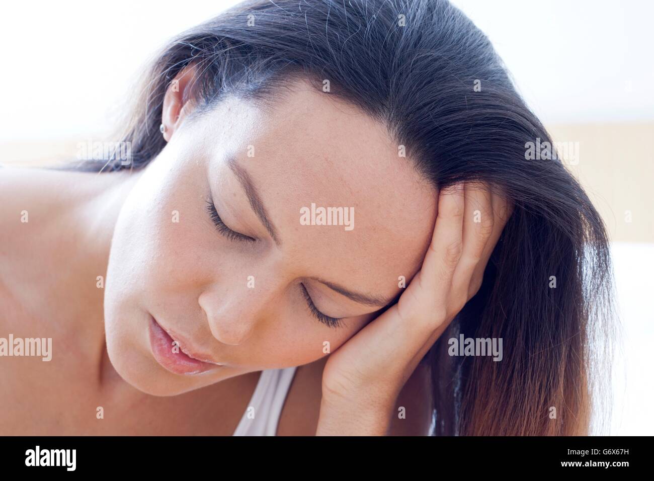 MODEL RELEASED. Tired young woman with her eyes closed. Stock Photo