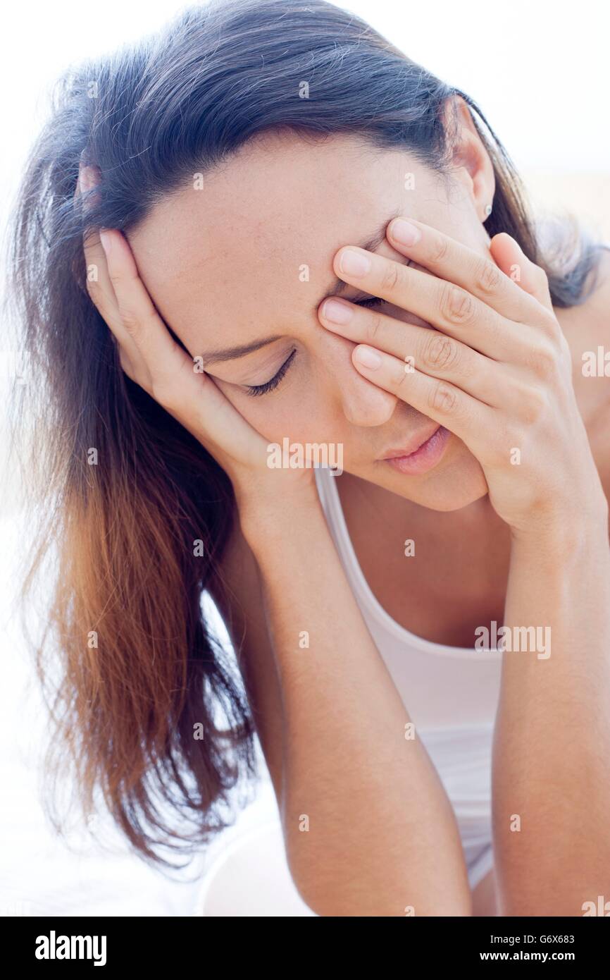 MODEL RELEASED. Tired young woman rubbing her eyes. Stock Photo
