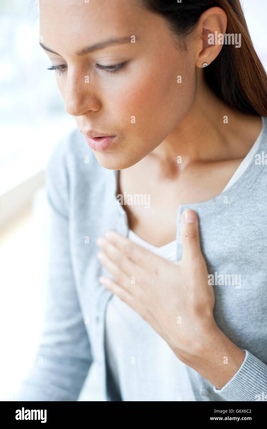 MODEL RELEASED. Young woman with her hand on her chest. Stock Photo