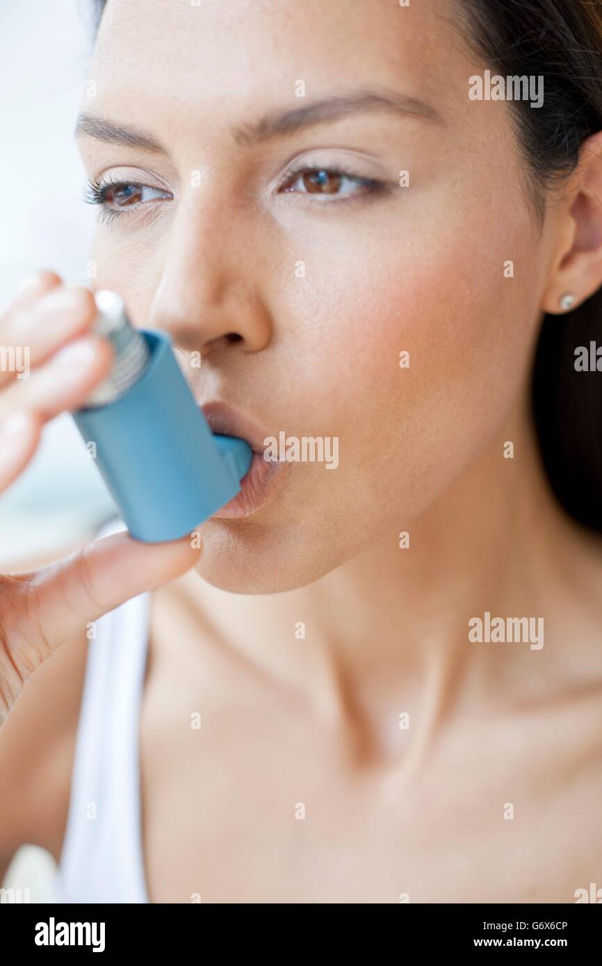 MODEL RELEASED. Young woman using an inhaler Stock Photo - Alamy