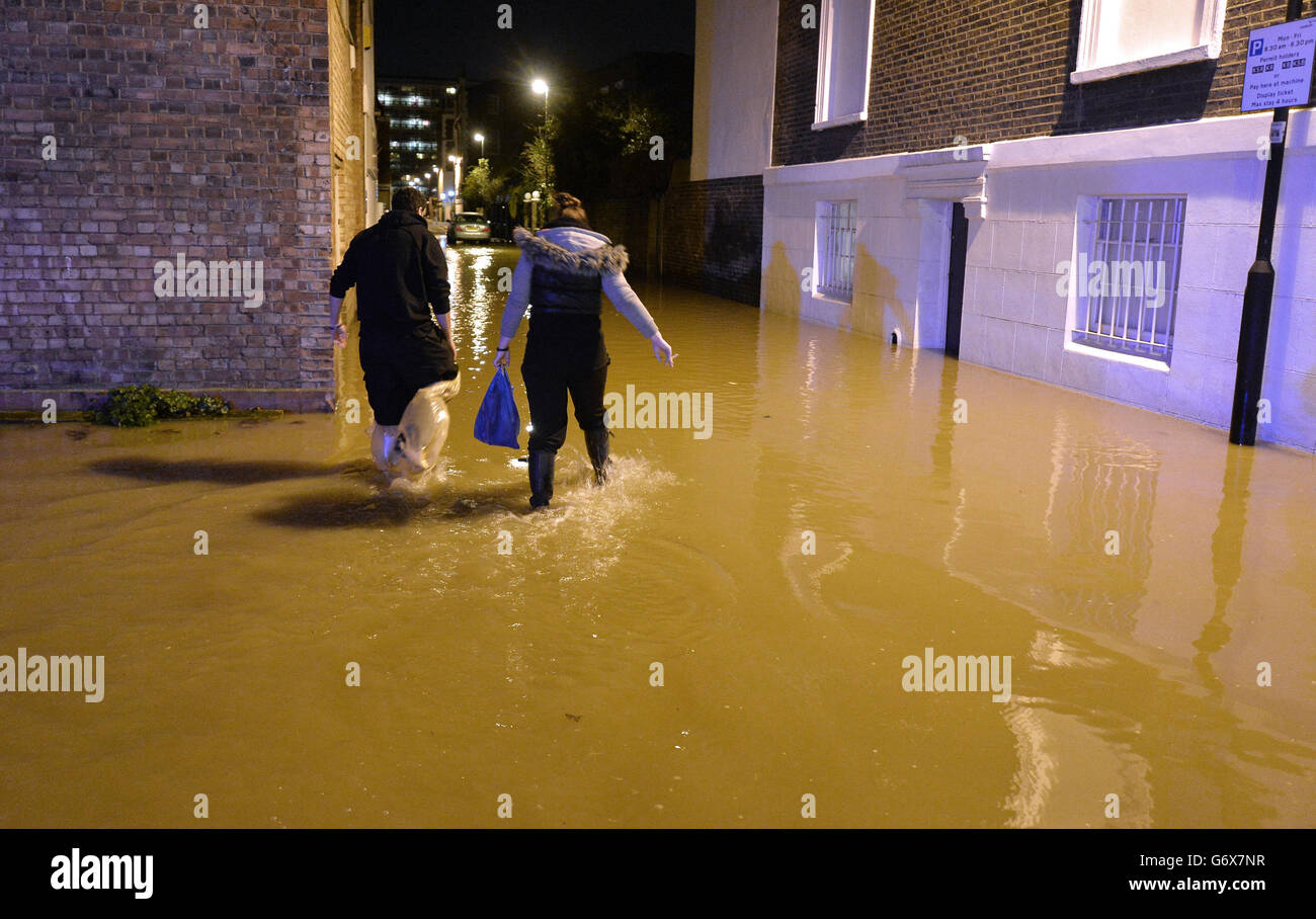 Kennington flooding. People walk through flood water from a burst main in Clapham Road in Kennington, south London. Stock Photo