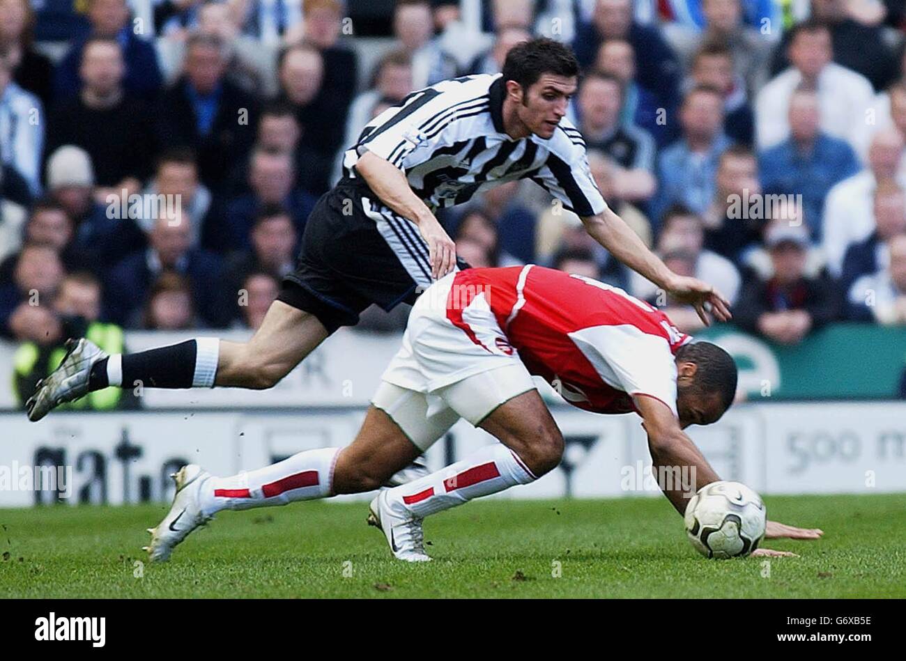 Arsenal's Thierry Henry falls over under the challenge of Andy O'Brien of Newcastle United during the Barclaycard Premiership match at Newcastle's St James' Park. Stock Photo