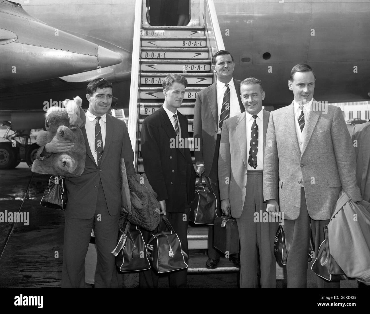 England and Surrey captain Peter May with other members of the MCC touring party on arrival at London Airport from the tour of Australia and New Zealand. (l-r) Freddie Truman, carrying a giant koala teddy bear; John Mortimore, Tom Graveney, Willie Watson and Peter May. Stock Photo