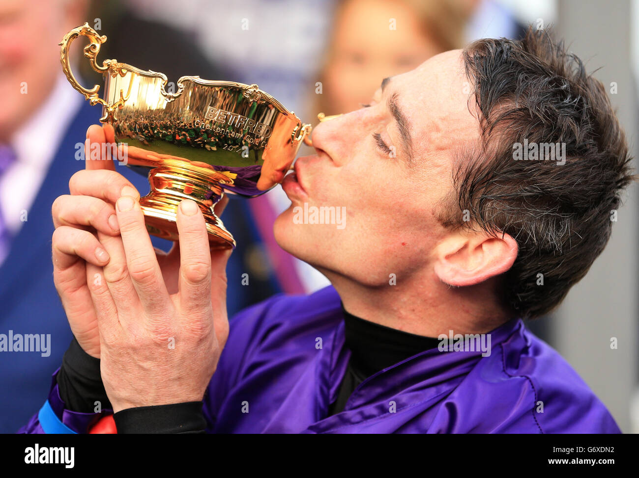 Horse Racing - 2014 Cheltenham Festival - Cheltenham Gold Cup Day - Cheltenham Racecourse. Jockey Davy Russell kisses The Betfred Cheltenham Gold Cup after winning onboard Lord Windermere Stock Photo