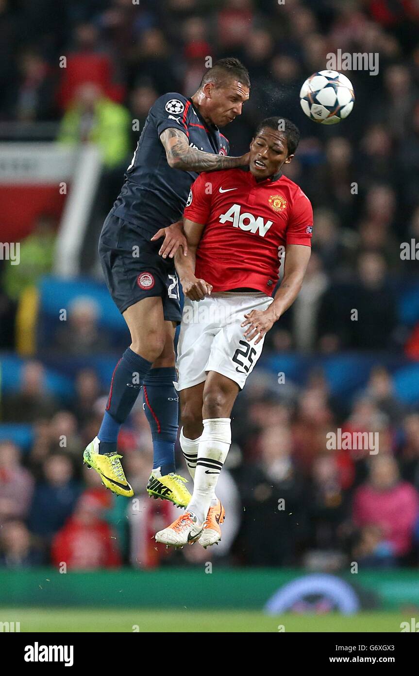 Olympiakos' Jose Holebas (left) and Manchester United's Antonio Valencia battle for the ball in the air Stock Photo