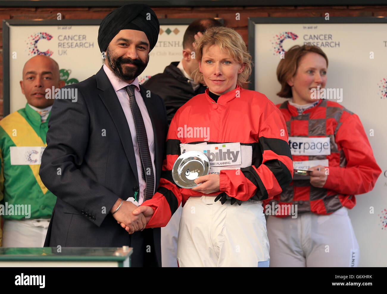 Competitors accept awards after competing in the Cancer Research UK charity race during St Patrick's Day at Cheltenham Racecourse Stock Photo