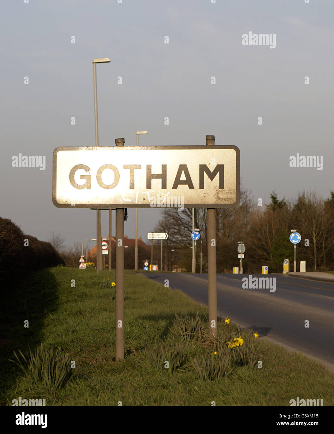 A Gotham Village road sign post, including where someone has written 'City' underneath. Stock Photo