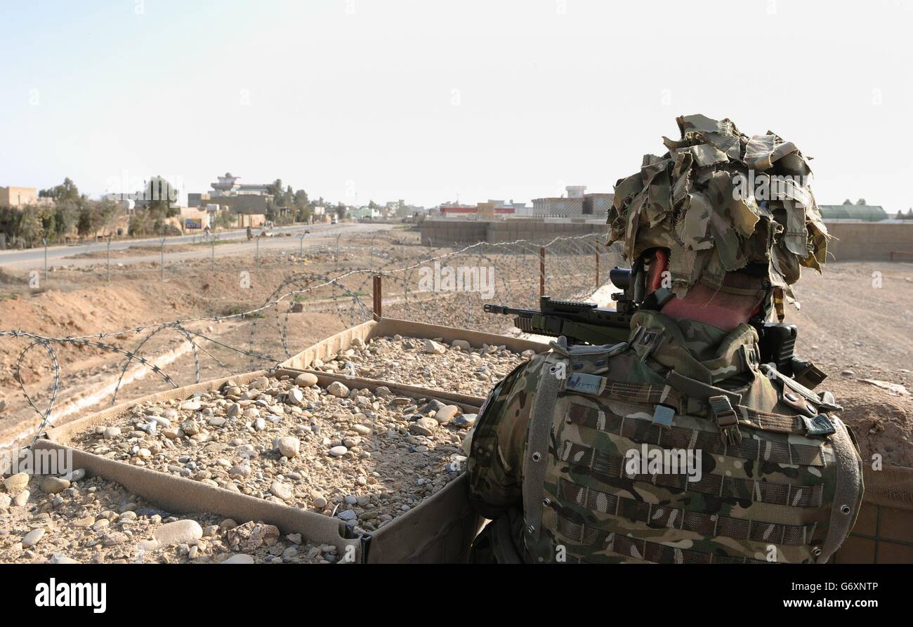 Soldier looks out over the perimeter fence of Main Operating Base Lashkar Gah in Helmand Province as British troops prepare to withdraw and hand over to Afghan security forces. 24/02/2014. Stock Photo