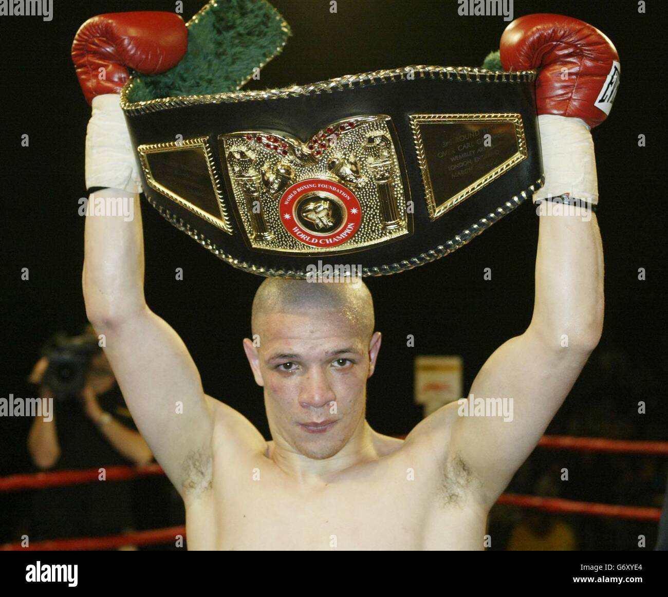 Carl 'Bo' Johanneson from Leeds (now based in USA) lifts title belt after his victory over Scotland's Andrew Ferrans in their WBF World Super Featherweight Championship at Whitchurch Sports Centre, Bristol. Stock Photo